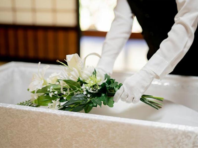 納棺の儀で棺にお花を入れている女性スタッフの手元